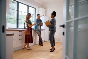 A couple reviews a home purchase offer and negotiations paperwork at their kitchen table.